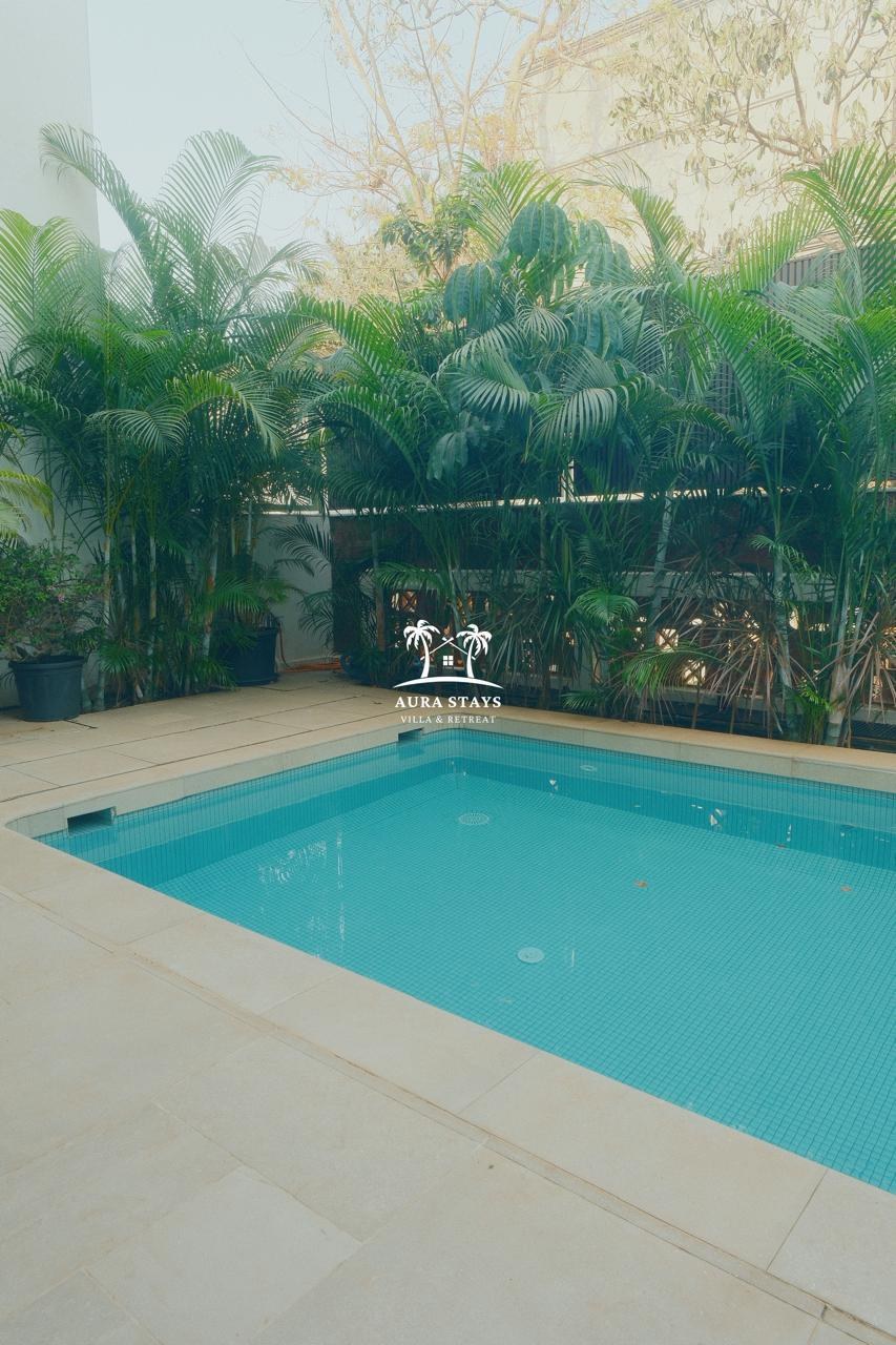 Aura Stays private swimming pool surrounded by tropical greenery